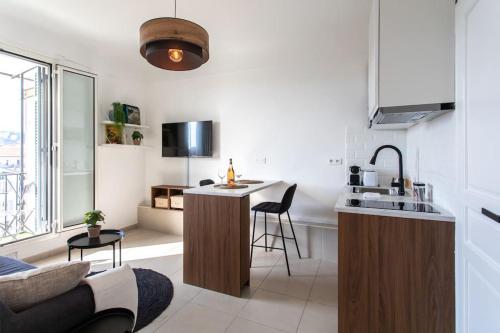 Il comprend une cuisine et un salon avec un évier et un comptoir. dans l'établissement L33 2P Jean Médecin centrale/ 2 Balcony & AC, à Nice