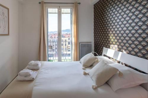 une chambre avec un grand lit blanc avec une fenêtre dans l'établissement L33 2P Jean Médecin centrale/ 2 Balcony & AC, à Nice
