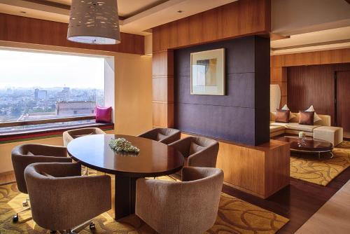 a living room with a table and chairs and a couch at Hyatt Regency Chennai in Chennai