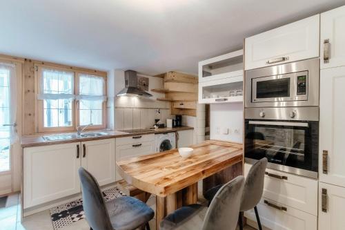 een keuken met een houten tafel en stoelen bij Casa Edera by Quokka 360 - typical romantic wooden house in Solduno