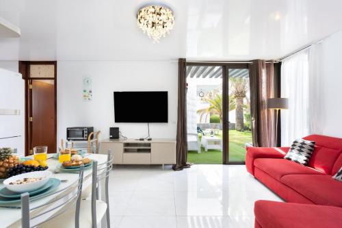 - un salon avec un canapé rouge et une télévision dans l'établissement Nice apartment in the heart of Las Americas, à Playa de las Americas