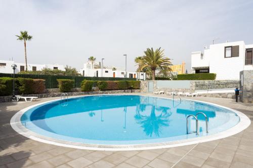 une grande piscine bleue dans une cour dans l'établissement Nice apartment in the heart of Las Americas, à Playa de las Americas