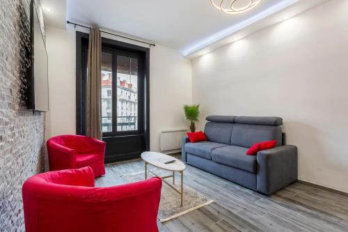uma sala de estar com um sofá e duas cadeiras vermelhas em Hamac Suites-Suite les Brotteaux em Lyon