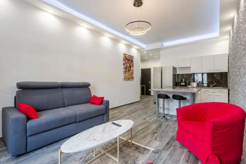 uma sala de estar com um sofá azul e uma cadeira vermelha em Hamac Suites-Suite les Brotteaux em Lyon