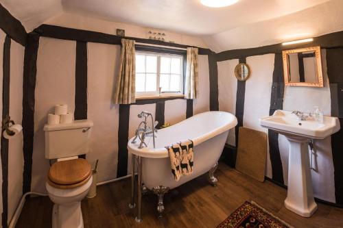 a bathroom with a tub and a toilet and a sink at Toad Hall in Swilland