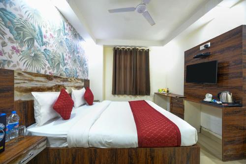 a bedroom with a large bed and a television at Grand Empire Suites By Delhi Airport in New Delhi