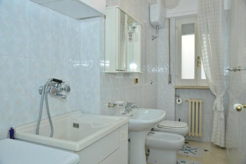 een witte badkamer met een wastafel en een toilet bij Frisio Reef Apartment- Sea View in Trani