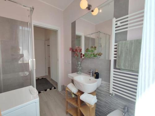 uma casa de banho branca com um lavatório e um chuveiro em Ampio e nuovissimo Trilocale 6 pax centrale em San Benedetto del Tronto
