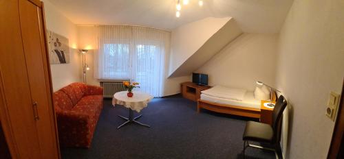 バート・ラーエルにあるPension Wortmannのベッド、ソファ、テーブルが備わるホテルルームです。