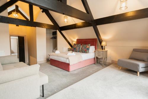 a bedroom with a bed and a couch and a chair at Newly Renovated 4 bed in Tarvin, Near Chester - Sleeps up to 15 in Tarvin
