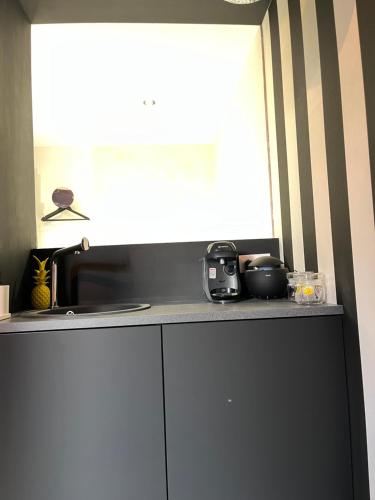 - une cuisine avec un comptoir, un évier et une fenêtre dans l'établissement Appartement avec Jacuzzi pour 2 personnes, à Villefranche-sur-Saône