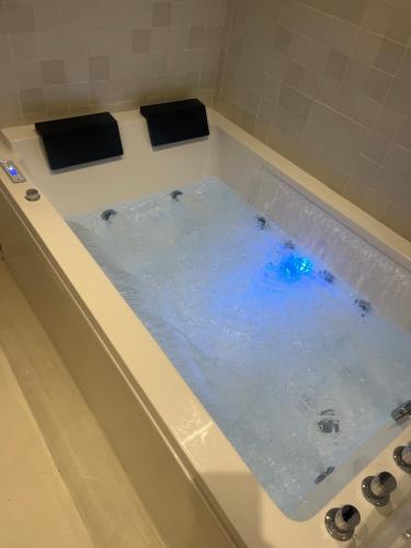 une baignoire remplie d'eau bleue dans l'établissement Appartement avec Jacuzzi pour 2 personnes, à Villefranche-sur-Saône