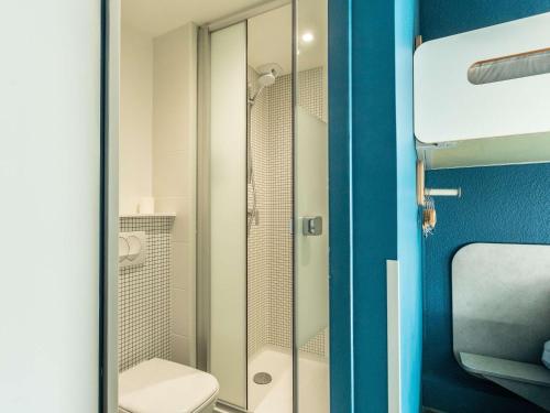 uma casa de banho com um chuveiro e um WC. em ibis budget Bourges em Bourges