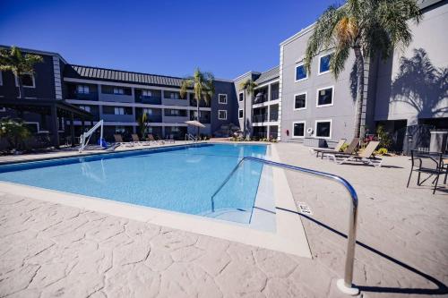 a large swimming pool in a courtyard with a building at La Quinta Inn by Wyndham Tampa Near Busch Gardens in Tampa