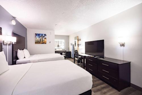 a hotel room with two beds and a flat screen tv at La Quinta Inn by Wyndham Tampa Near Busch Gardens in Tampa