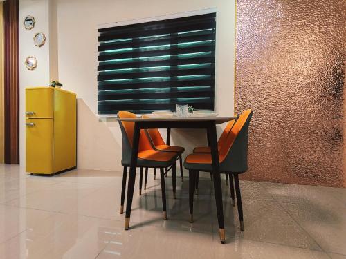 a dining room table with chairs and a yellow refrigerator at Pavilionvillie M1T692 by irainbow in Ipoh