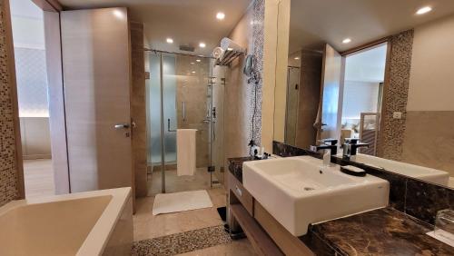 a bathroom with a sink and a shower and a tub at Radisson Blu Hotel, Greater Noida in Greater Noida