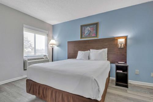 um quarto com uma cama grande e uma grande colcha branca em Baymont by Wyndham North Myrtle Beach em Myrtle Beach