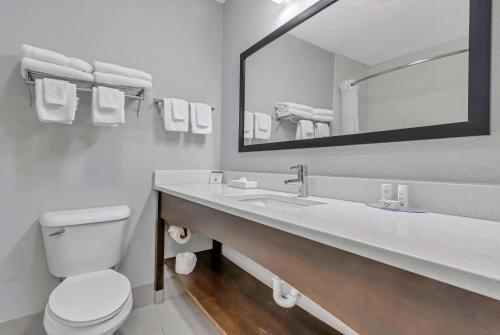 a bathroom with a toilet and a sink with a mirror at Baymont by Wyndham North Myrtle Beach in Myrtle Beach
