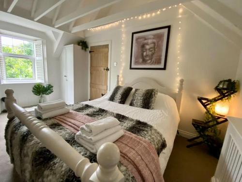 a bedroom with a large bed with lights on it at Clover Neuk Mews Cottage, 34a Main Road in Fairlie