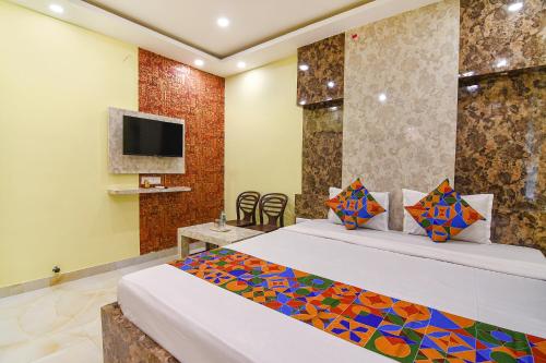 a hotel room with a bed and a tv at FabHotel Divine Chariot in Kolkata
