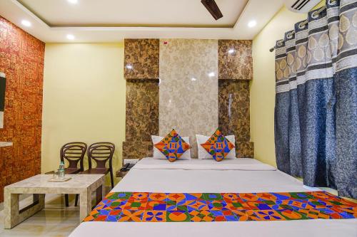 a room with a bed and a table and chairs at FabHotel Divine Chariot in Kolkata