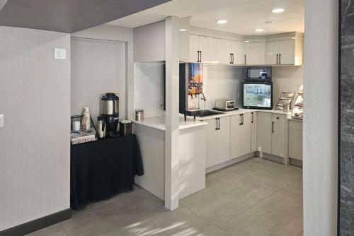 a kitchen with white cabinets and a black counter top at Rodeway Inn & Suites in Kamloops