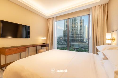 ein Hotelzimmer mit einem großen Bett und einem großen Fenster in der Unterkunft Address Opera - Lux 3 BR with Full Burj Khalifa View near Dubai Mall in Dubai