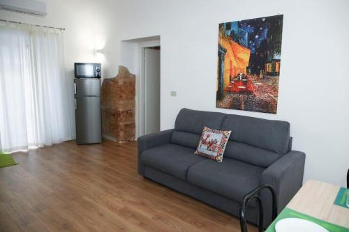 a living room with a couch and a refrigerator at Quattro Canti - residenza Santa Caterina in Palermo
