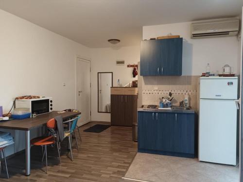 een keuken met een tafel en een witte koelkast bij Đurđina Apartment in Budva
