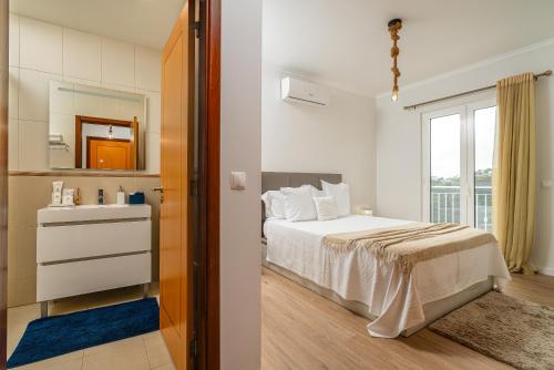 カリェタにあるCasa Agrela by Rent2U, Ldaのベッドルーム1室(ベッド1台、鏡、窓付)