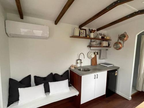 a kitchen with a bench and a sink in a room at Cozy & Thoughtful Tiny Home in Kallangur