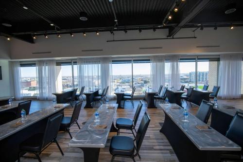 a large room with tables and chairs and windows at Lorenzo Hotel Dallas, Tapestry Collection by Hilton in Dallas