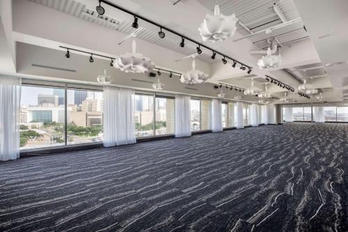 an empty ballroom with large windows and a large carpeted floor at Lorenzo Hotel Dallas, Tapestry Collection by Hilton in Dallas