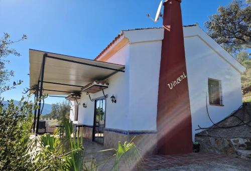 eine kleine weiße Kapelle mit einem roten Leuchtturm in der Unterkunft Finca el Moralejo 6 persons cottage in Tolox
