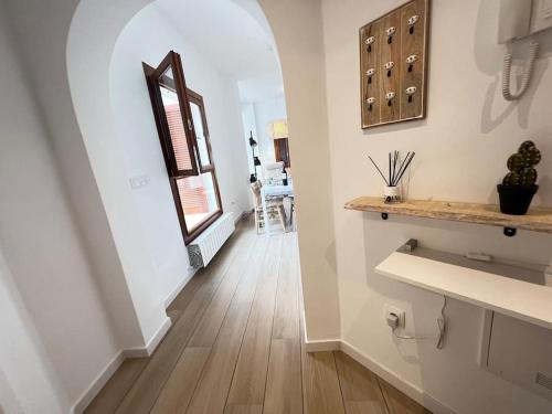 einen Flur eines Hauses mit weißen Wänden und Holzböden in der Unterkunft Apt Diamante El Valle Golf in Baños y Mendigo