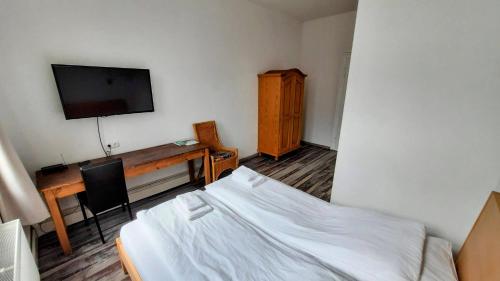 - une chambre avec un lit, un bureau et une télévision dans l'établissement Am Lindenhof - Self Check-In Hotel, à Hanovre