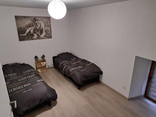 1 dormitorio con 2 camas y un cartel en la pared en Charmante maison Ardennaise, en Hampteau