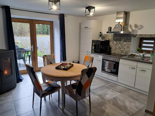 cocina con mesa y sillas y cocina con fogones en Charmante maison Ardennaise, en Hampteau