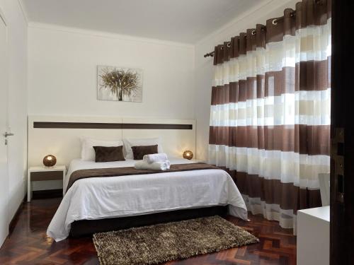 a bedroom with a large bed and a window at The Rock Guest House in Ponta Delgada