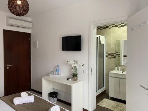 uma casa de banho branca com um lavatório e um espelho em The Rock Guest House em Ponta Delgada