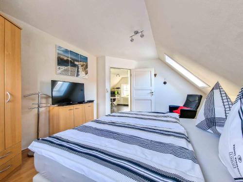um quarto com uma cama grande e uma televisão em Sonnendeck em Greetsiel