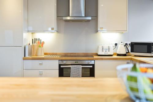 uma cozinha com armários brancos e um forno com placa de fogão em Westcliff Penthouse with Sea Views and Balcony em Bournemouth
