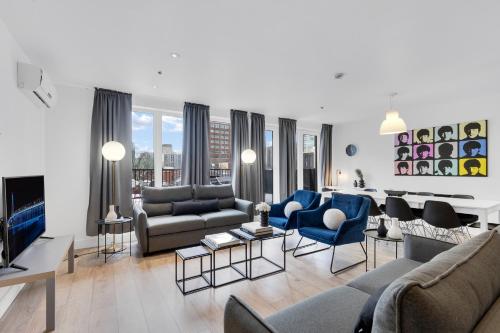 a living room with a couch and a tv at LiV MTL Downtown Montreal Spacious Suites in Montreal