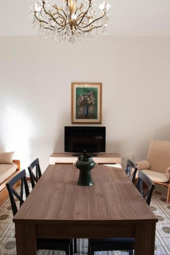 une salle à manger avec une table en bois et un lustre dans l'établissement Casa Doré in South Sardinia, à Sìnnai