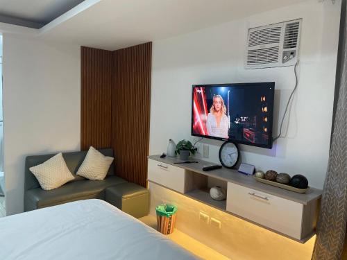 a hotel room with a bed and a flat screen tv at Studio Anna in Cebu City