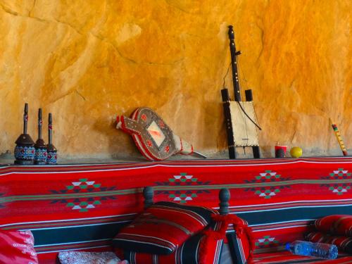 un banc rouge à motifs rouges et bleus dans l'établissement Wadi rum view camp, à Wadi Rum