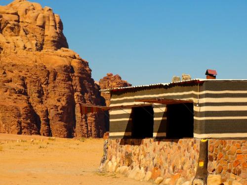 un edificio en el desierto con una pared de roca en Wadi rum view camp, en Wadi Rum