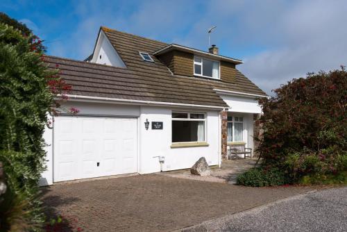 a house with a white garage with a roof at Talland Croft in Crantock