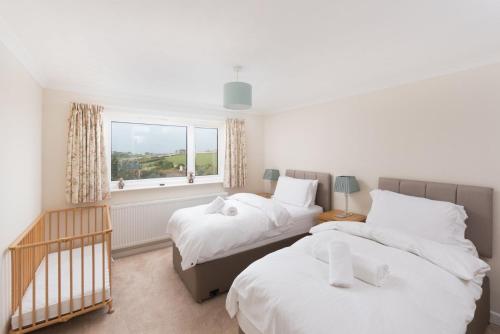 um quarto com 2 camas e uma janela em Talland Croft em Crantock